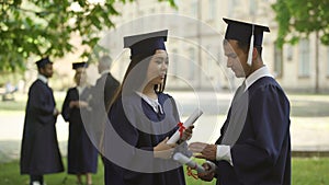 International graduates with diplomas having conversation, studying on exchange