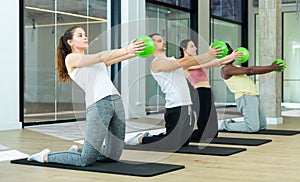 Sporty young adults doing pilates exercises with bender balls photo