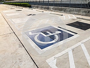 International handicapped wheelchair or Disabled parking symbol painted in bright blue on parking space