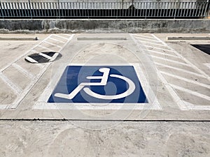 International handicapped wheelchair or Disabled parking symbol painted in bright blue on parking space