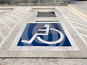 International handicapped wheelchair or Disabled parking symbol painted in bright blue on parking space