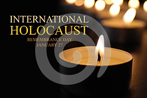 International Holocaust Remembrance Day January  27. Burning candle on table in darkness, closeup