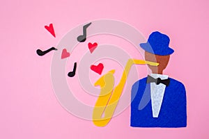 International Jazz Day. A silhouette of a musician with a saxophone from which hearts and melodies flew out, on a pink background
