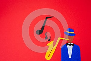 International Jazz Day. Silhouette of a musician with a saxophone from which melodies flew out, on a red background