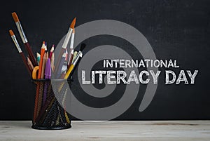 International Literacy Day. School Stationary on Blackboard photo