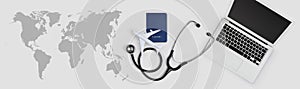 International medical travel insurance concept, stethoscope, passport, laptop computer and airplane on desk office banner with