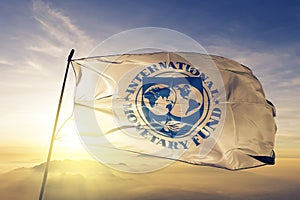 International Monetary Fund IMF flag textile cloth fabric waving on the top sunrise mist fog