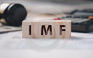 A photograph with the word imf on a wooden block. photo