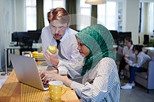 International multicultural business team working together on laptop