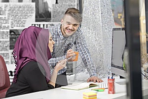 International multicultural team at work: asian muslim woman and caucasian man.