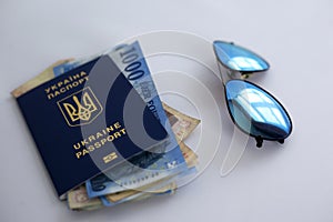 international passport of Ukraine, money and glasses on a white background. `The concept of travel without unnecessary things`