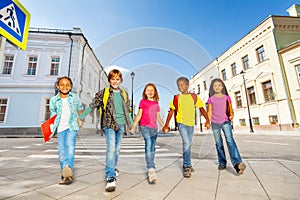 International schoolchildren walk and hold hands