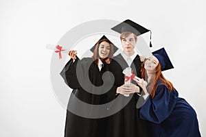 International students graduates rejoicing smiling posing over white background.