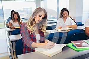 International students writing in lecture hall and talking