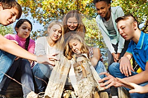 International teens construct bonfire together