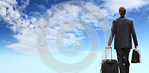 International travel business man, success concept, businessman back view walking with trolley and briefcase, isolated on blu sky