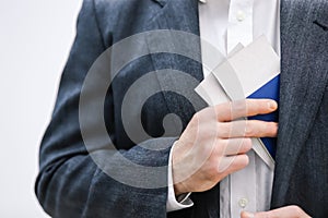 Cropped shot of businessman taking travel documents out of the inner pocket of his jacket.