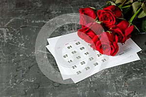 International Womans day concept with calendar pages of year 2021 of march and red roses on gray background