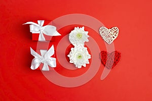 International Women`s Day card with gifts, hearts and chrysanthemum flowers  in the form of eight on red background