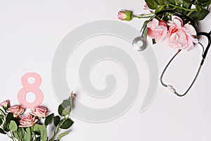 International Women`s Day card with stethoscope and pink roses flowers on white background. March 8. Congratulations to medical