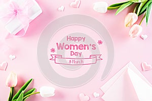 International Women`s Day concept. Pink and white tulips with gift box and paper tag text on pink pastel background. Top view fla