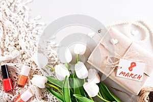 International Women`s Day concept. Woman lace lingerie jewelry perfume present with white tulips and paper tag text on soft fabri