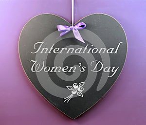 International Women's Day message written on heart shape blackboard photo