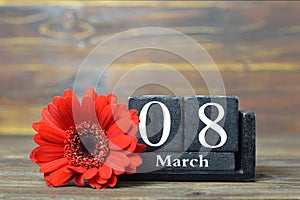 International Womens Day card. Wooden calendar and red gerbera flower