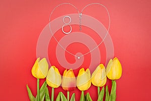 International Womens Day with flowers and heart shape necklace on red background