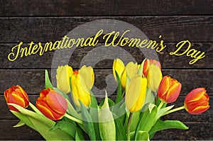 International Womens day text sign on wooden rustic background with colorful tulips. greeting card, poster. Spring Tulips.