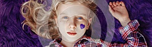 International world epilepsy illness awareness day. Cute pretty blonde Caucasian girl with small violet purple paper heart on her