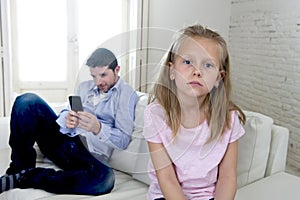 Internet addict father using mobile phone ignoring little sad daughter bored lonely and depressed