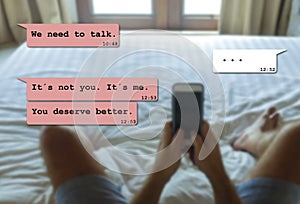 Internet chat composite with young man in bed dumped by his girfriend via mobile phone receiving painful text and break up