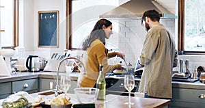 The internet is choc full of recipes. a young couple using a digital tablet while preparing a meal at home.