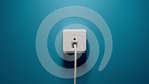 Internet Cord Into Wall Socket on a blue wall