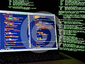 Internet crime concept. Hacker working on a code on dark digital background with digital interface around. Hacker workspace