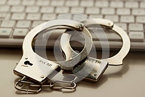 Internet crime hacker cyberattack. Stalking, phishing cyberterrorism. Handcuffs on keyboard