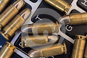 Internet dangers concept. Close up of bullets and laptop keyboard