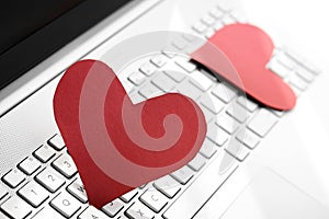 Internet dating concept - two paper hearts on computer keyboard