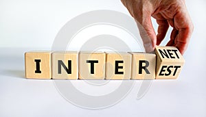 Internet and interest symbol. Businessman turns wooden cubes and changes the words interest to internet. Beautiful white