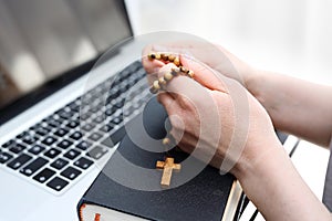 Internet Mass. A woman prays at the rosary. photo