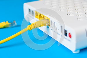 Internet modem router hub with a cable connecting on blue background