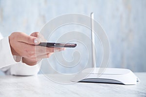 Internet router in the desk. Girl using smartphone