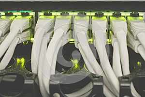 Internet switch with gigabit links is a close-up. The cables patch panel and network hub is in the server room data center. Many