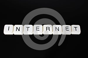 Internet text word title caption label cover backdrop background. Alphabet letter toy blocks on black reflective background. White