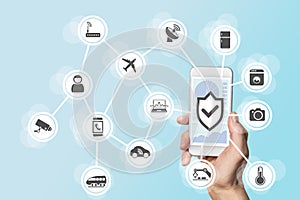 Internet of things security concept with hand holding modern smart phone to control intruders into a network of objects