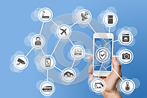 Internet of things security concept illustrated by hand holding modern smart phone with connected sensors in objects