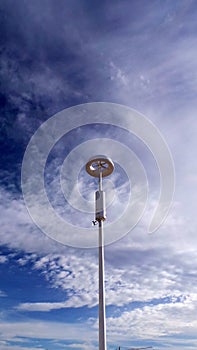 Internet, WiFi tower against the background of a bright blue cloudy sky.