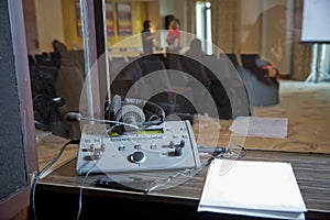 Interpreting - Microphone and switchboard in an simultaneous interpreter booth . Soft focus of wireless Conference microphones and
