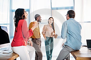 interracial business colleagues having conversation during coffee break